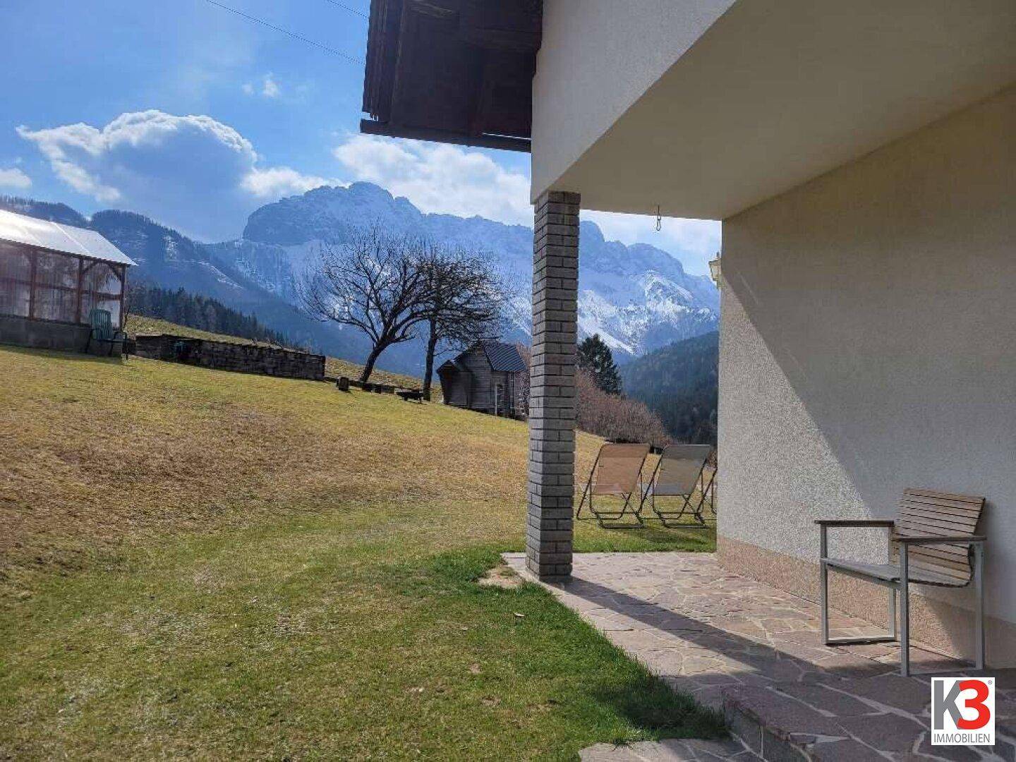 Gemütliche Terrasse mit Sitzgelegenheiten und weitem Blick auf die umliegende Berglandschaft.