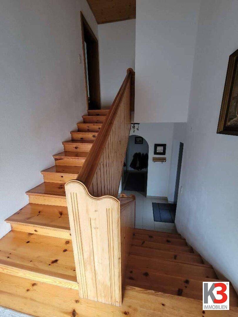 Geräumiges Treppenhaus mit Massivholzstufen und traditioneller Holzvertäfelung.