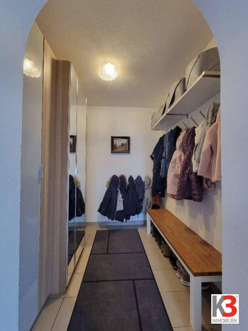 Praktischer Flur mit Einbauschränken, Garderobe und Sitzbank für den Eingangsbereich.