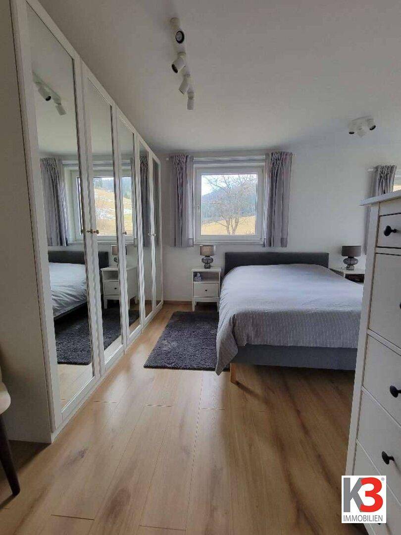 Gemütliches Schlafzimmer mit Doppelbett, Spiegelschränken und Blick ins Grüne.