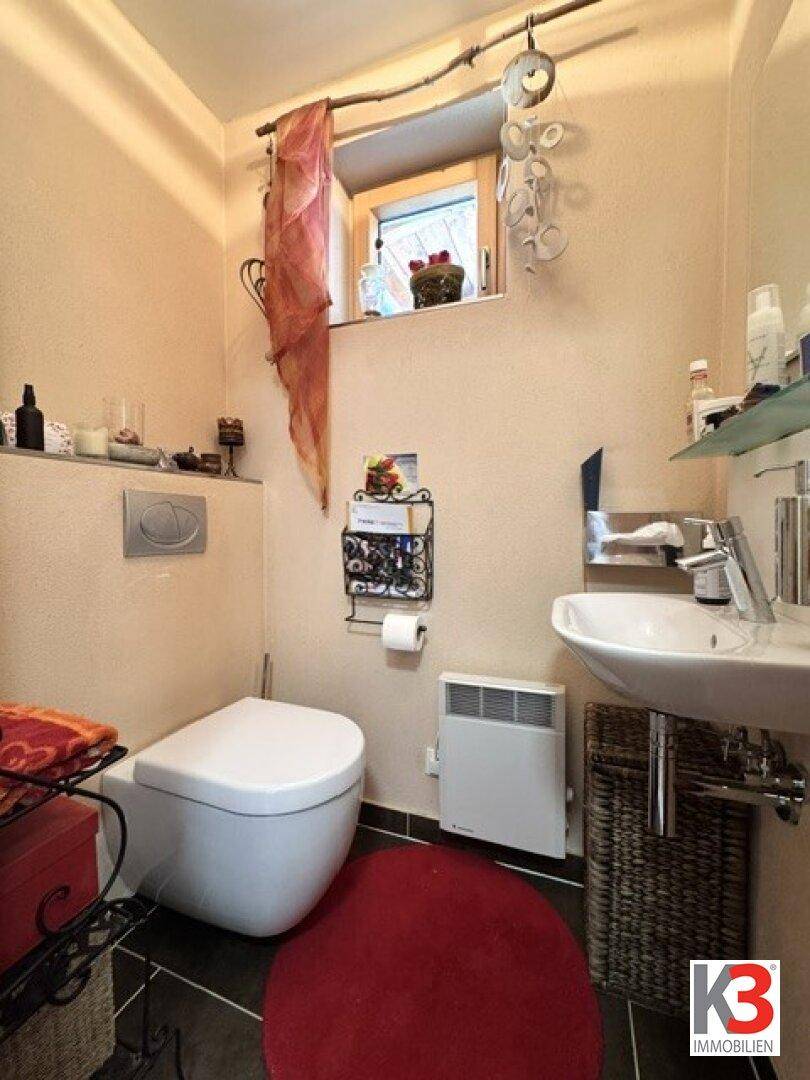 Kleines Gäste-WC mit Fenster, wandhängendem WC und Heizkörper.