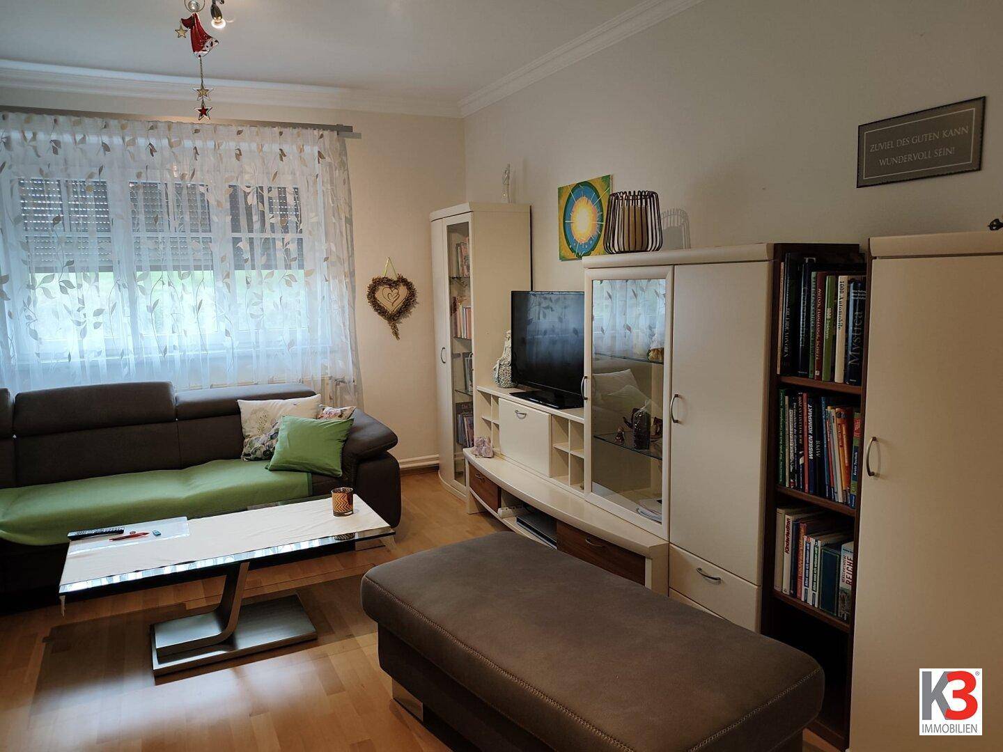 Wohnzimmer mit Laminatboden, bequemer Couch und einem Medientisch, ideal zum Entspannen.