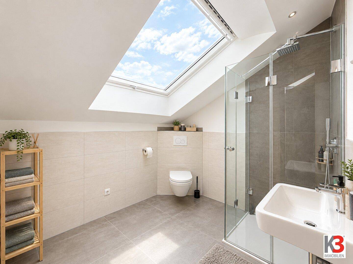 Helles Badezimmer im Dachgeschoss mit Dusche, WC und großem Dachfenster.