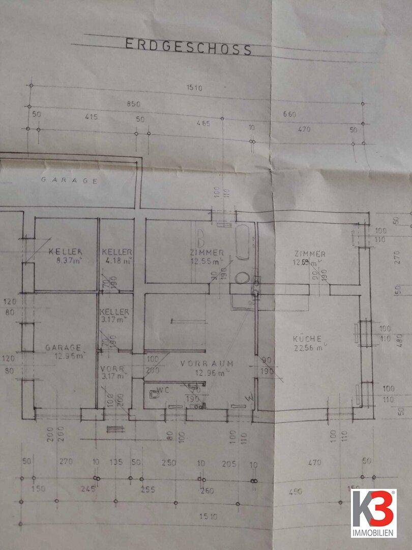 Grundriss des Erdgeschosses mit Garage, Kellerräumen, Küche und weiteren Zimmern.