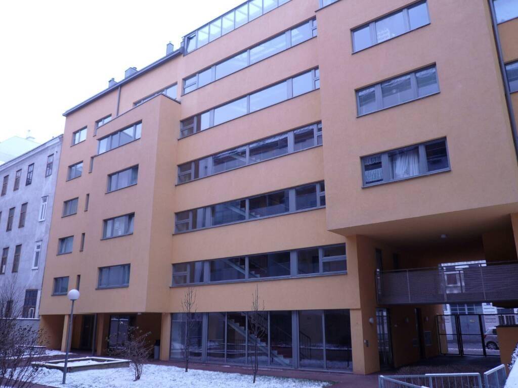 Moderne Wohnanlage mit großen Fenstern und flachem Dach, umgeben von Schnee.