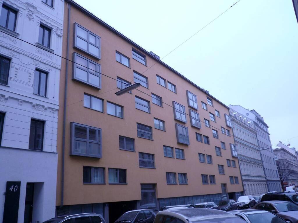 Seitenfassade eines modernen Wohngebäudes mit vielen Fenstern an einem Wintertag.