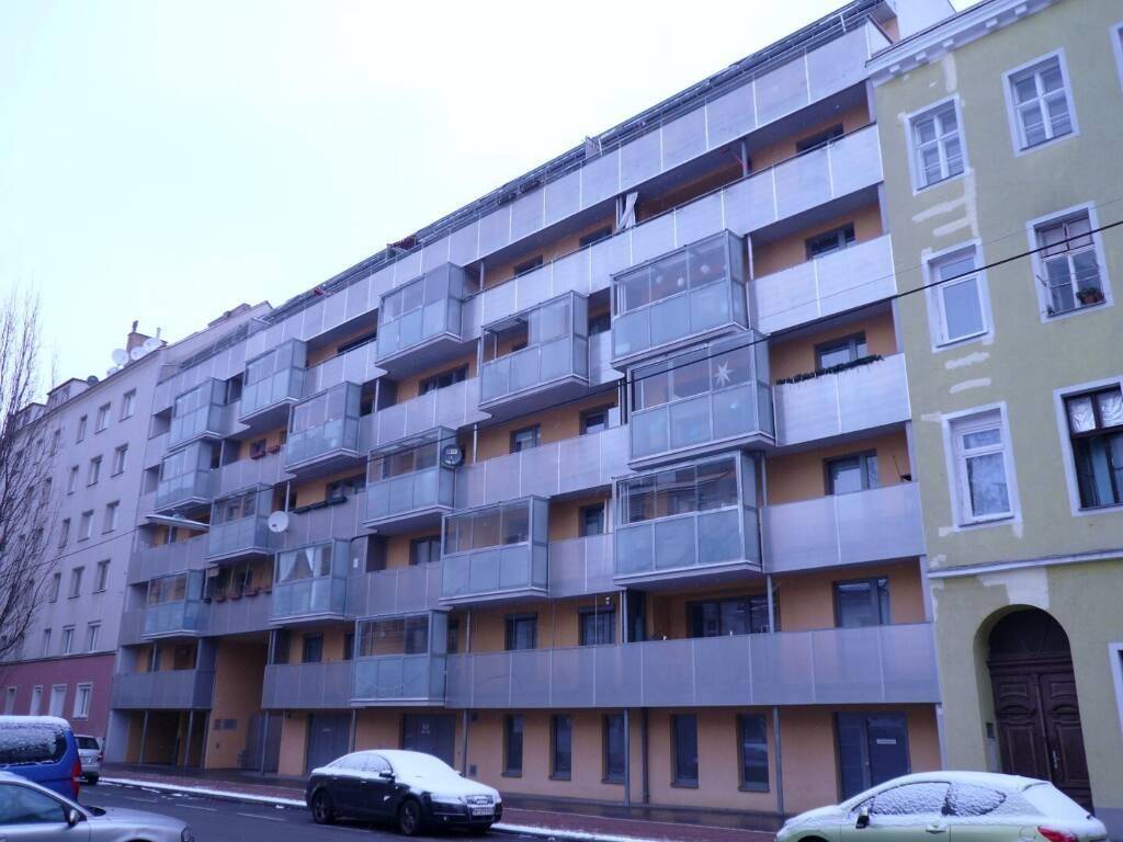 Mehrstöckiges Wohngebäude mit zahlreichen Balkonen und moderner Fassade im Winter.