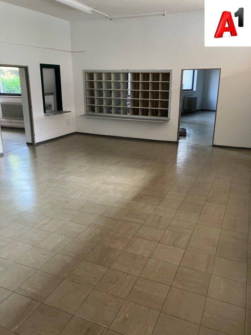 Weiterer Blick in den offenen Verkaufsraum mit hellem Fliesenboden und Service-Schalter.