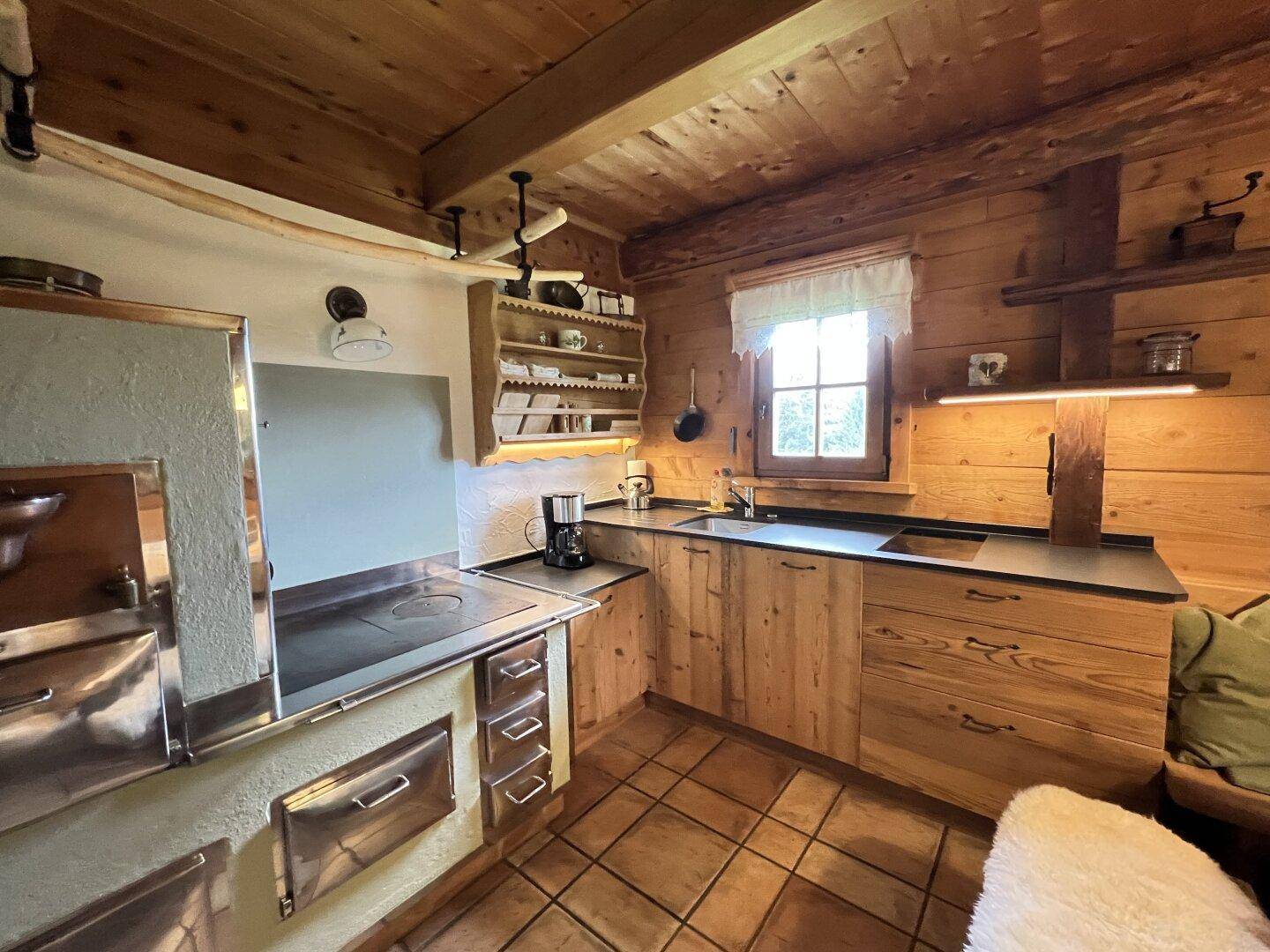 Gemütliche Holzküche im Landhausstil mit traditionellem Holzherd und modernen Arbeitsflächen.
