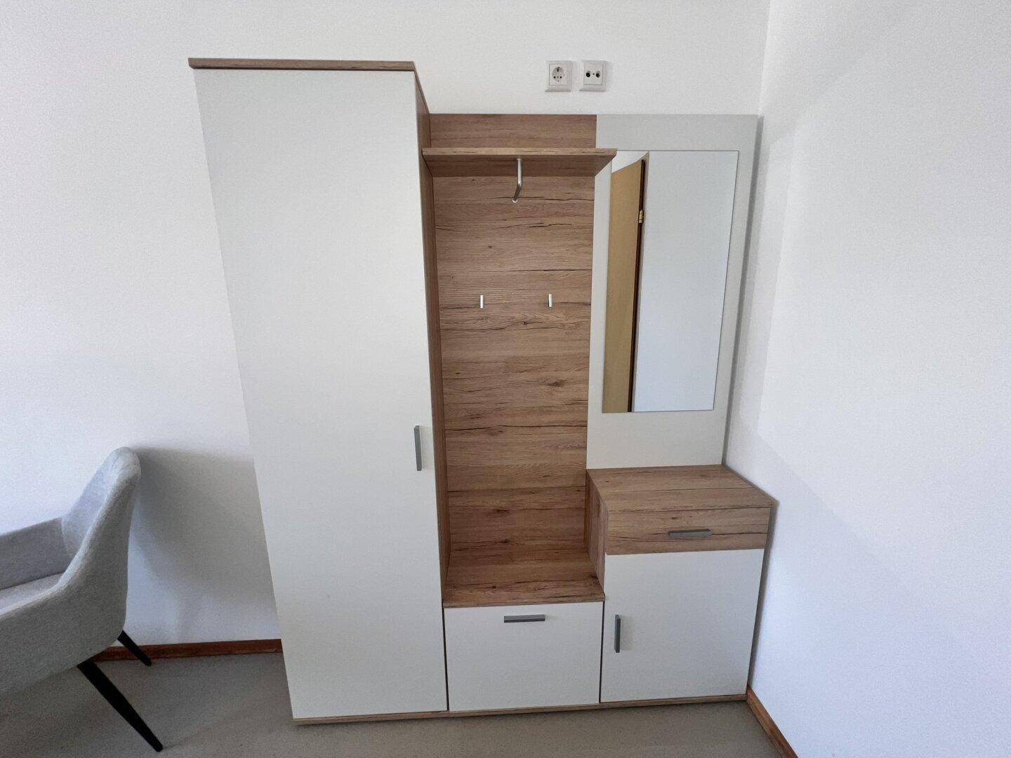 Moderner Kleiderschrank in Weiß und Holzoptik mit integriertem Spiegel und Garderobenhaken.