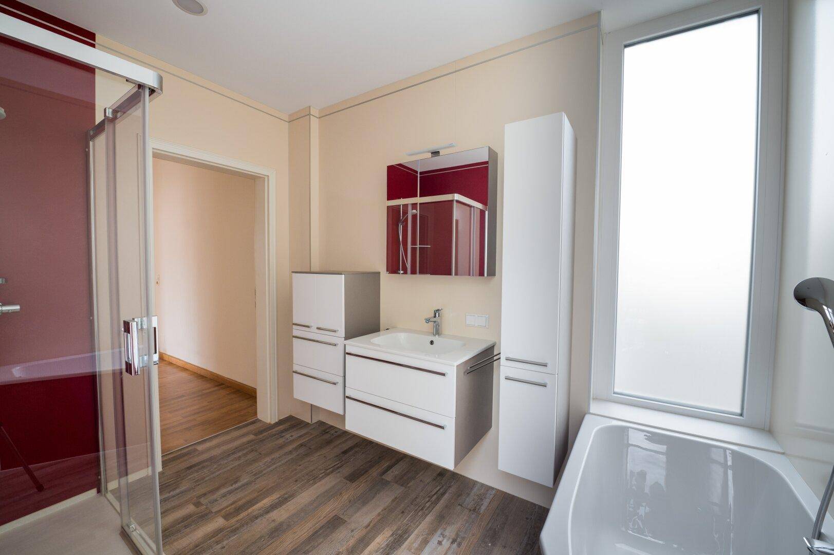 Stilvolles Badezimmer mit modernem Waschtisch, Spiegelschrank und großer Duschkabine.