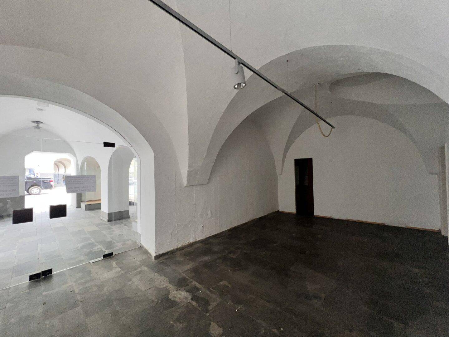 Großer Innenraum mit beeindruckenden Gewölbedecken und dunklem Steinboden, bereit für die Gestaltung.
