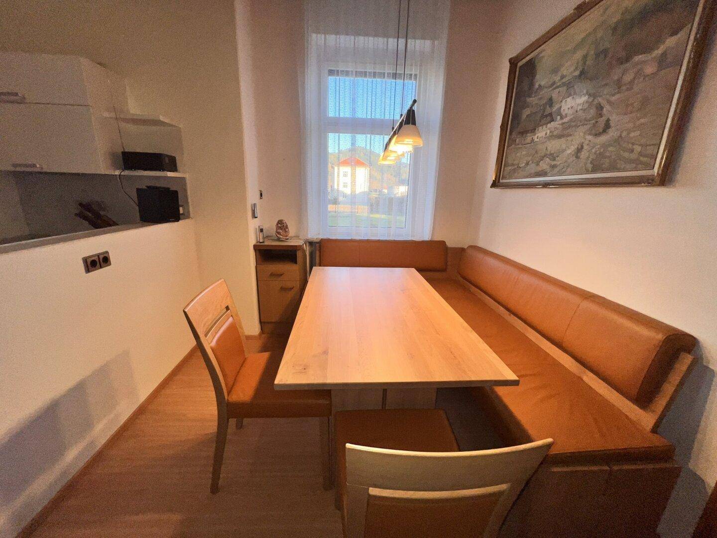Gemütlicher Essbereich mit Eckbank, Holztisch und Fenster für natürliches Licht.
