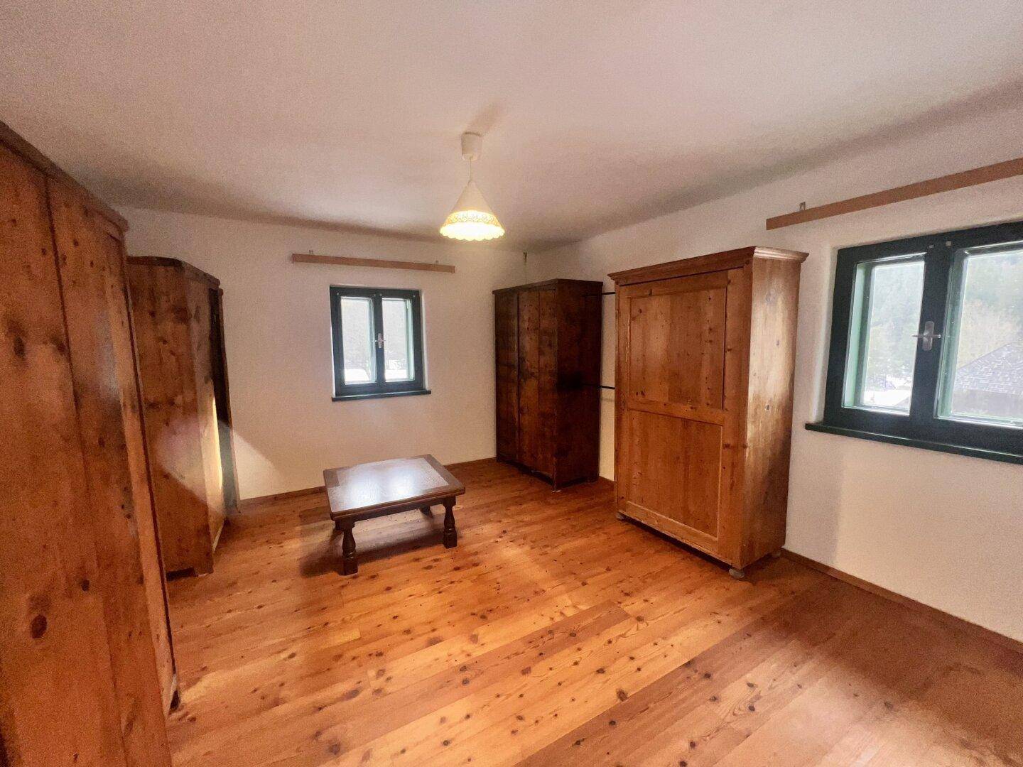 Schlafzimmer mit Holzdielenboden, traditionellen Holzschränken und natürlichem Lichteinfall.