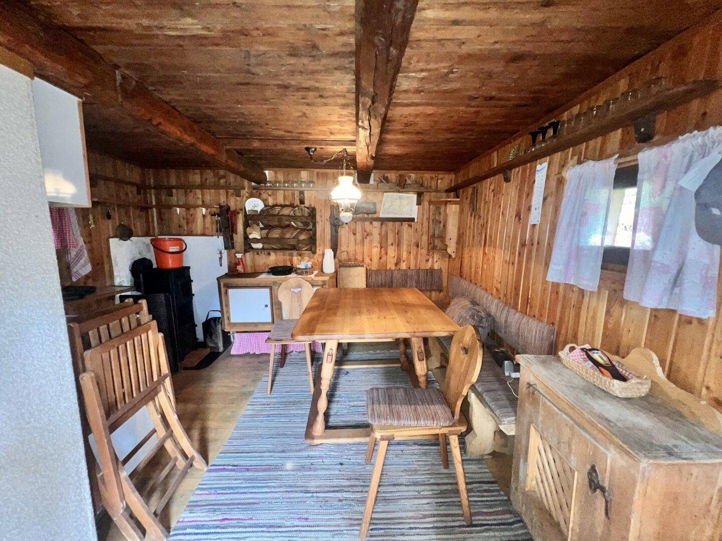 Gemütliche Wohnküche im alpinen Stil mit Holztäfelung, Esstisch und traditioneller Einrichtung.