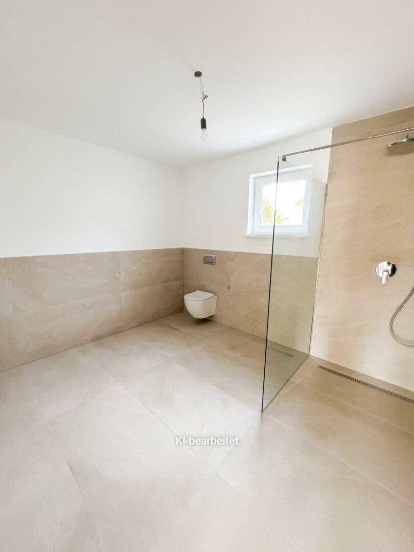 Modernes Badezimmer mit bodengleicher Dusche, wandhängendem WC und Fenster.