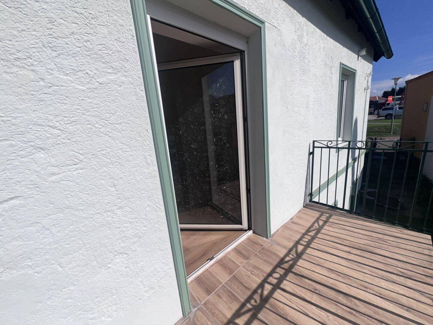 Balkon mit Fliesenboden und Blick auf die Umgebung, direkt vom Zimmer aus begehbar.