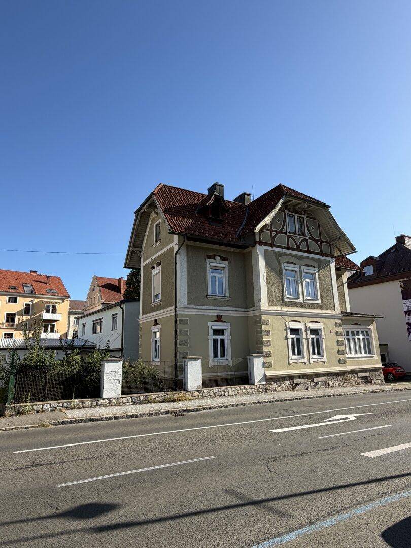 Historisches Gebäude mit traditioneller Architektur und Satteldach, gut gepflegt an einer Straße gelegen.