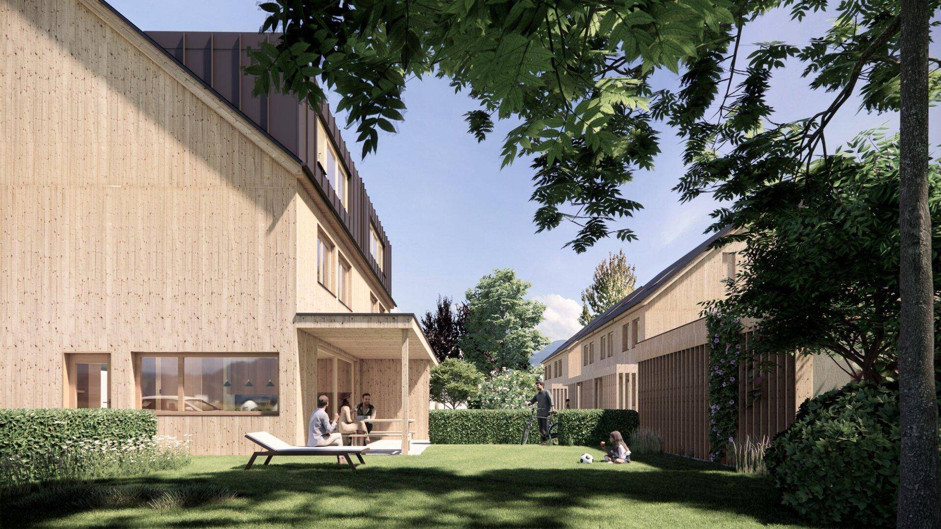 Gepflegter Gartenbereich hinter den Häusern mit Rasenfläche, Terrasse und Sitzgelegenheiten.