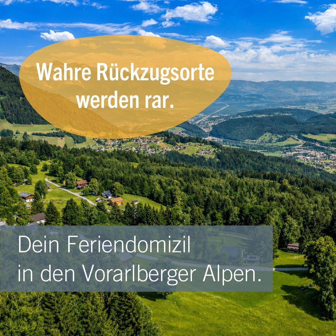 Weitläufige grüne Berglandschaft mit verstreuten Häusern und einem weiten Blick über die Region.
