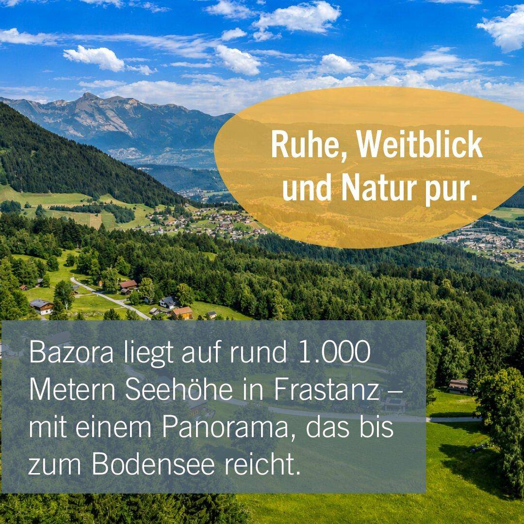 Malerische Berglandschaft mit grünen Wäldern und einem Dorf im Tal unter blauem Himmel.
