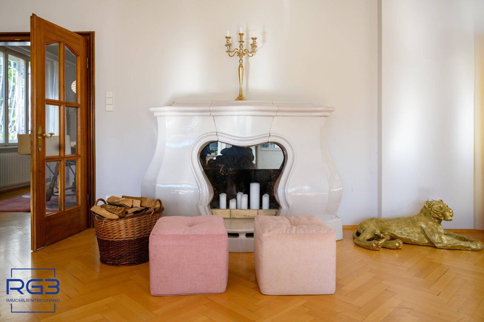 Detailansicht eines eleganten Kachelofens mit Holzkorb und dekorativen Elementen im Wohnbereich.