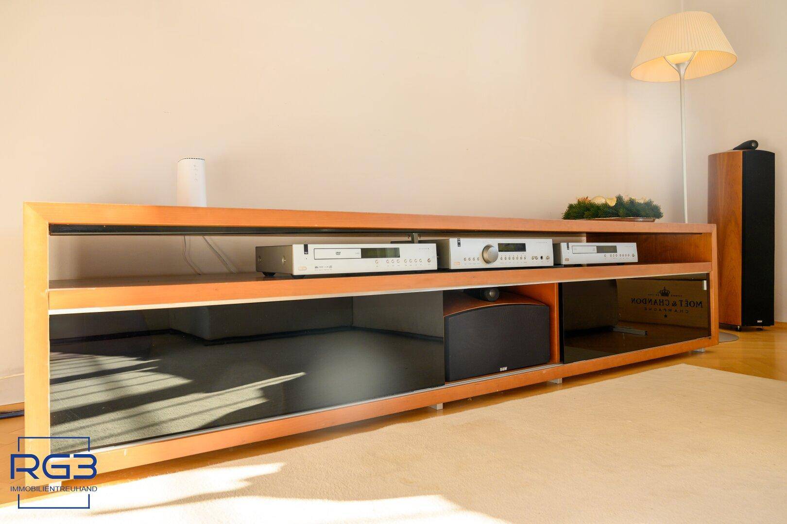 Moderner Medienbereich mit Holzregal, Hi-Fi-Anlage und Teppichboden im Wohnzimmer.