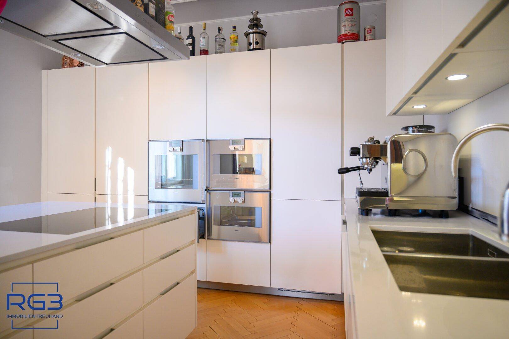Moderne, weiße Einbauküche mit integrierten Geräten und viel Stauraum.