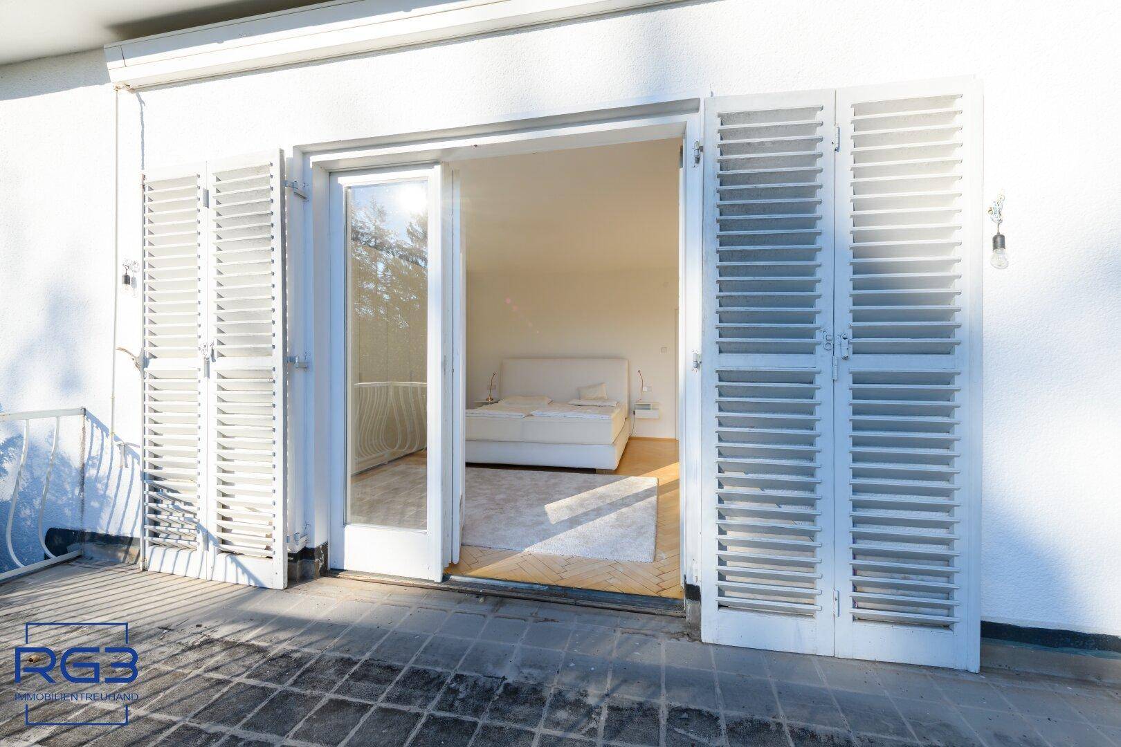 Sonniger Balkon mit Fliesenboden und Blick auf die Umgebung, zugänglich vom Schlafzimmer.