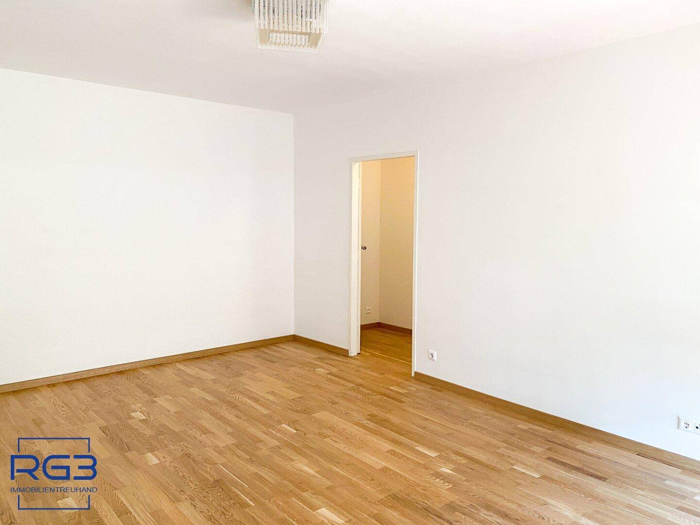 Heller, leerer Raum mit Parkettboden und weiß gestrichenen Wänden, bereit zur individuellen Gestaltung.