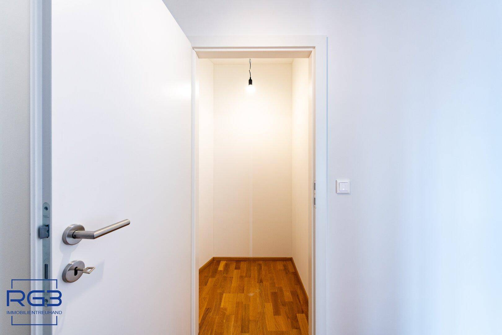 Kleiner Abstellraum mit Parkettboden und einfacher Beleuchtung, ideal für zusätzlichen Stauraum.