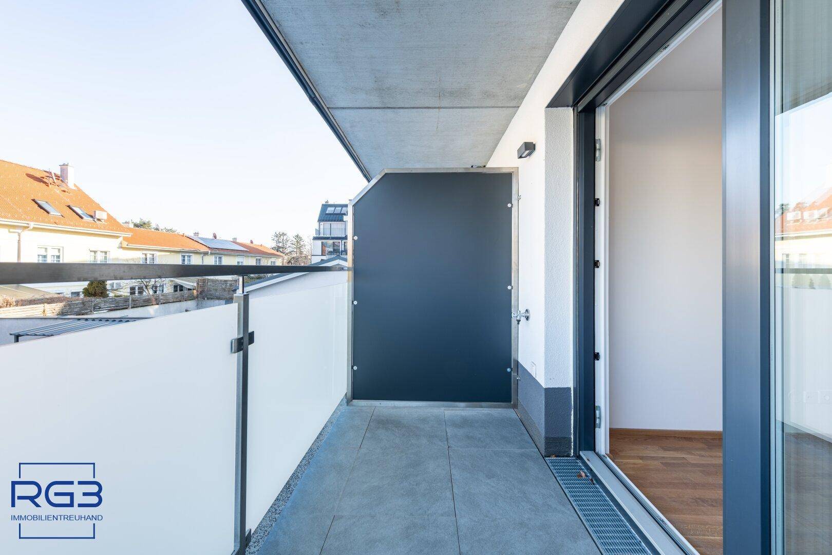 Schmaler Balkon mit Fliesen und Sichtschutz, ideal für entspannte Stunden im Freien.