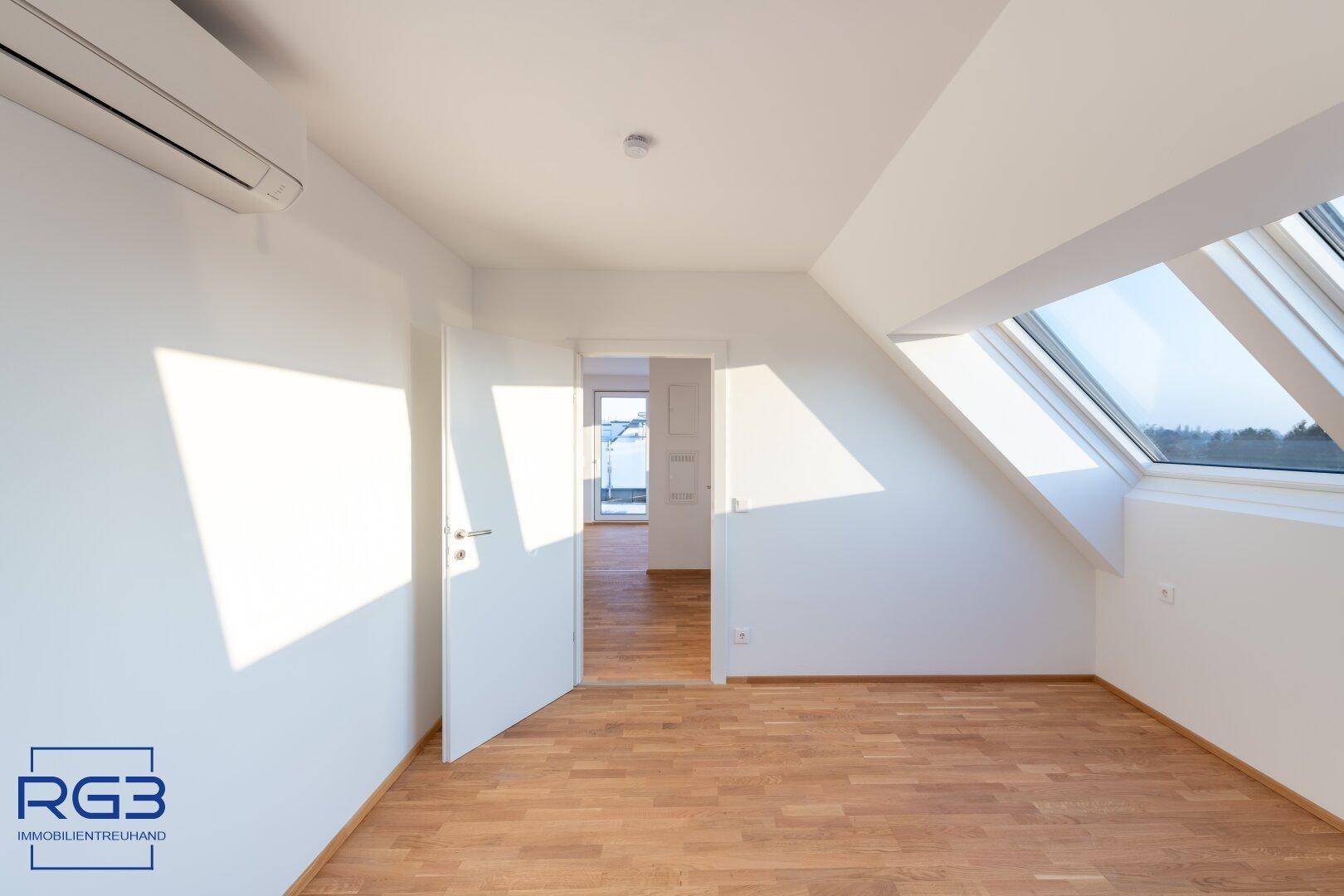 Geräumiges Zimmer mit Parkettboden, Dachfenstern und viel natürlichem Licht.