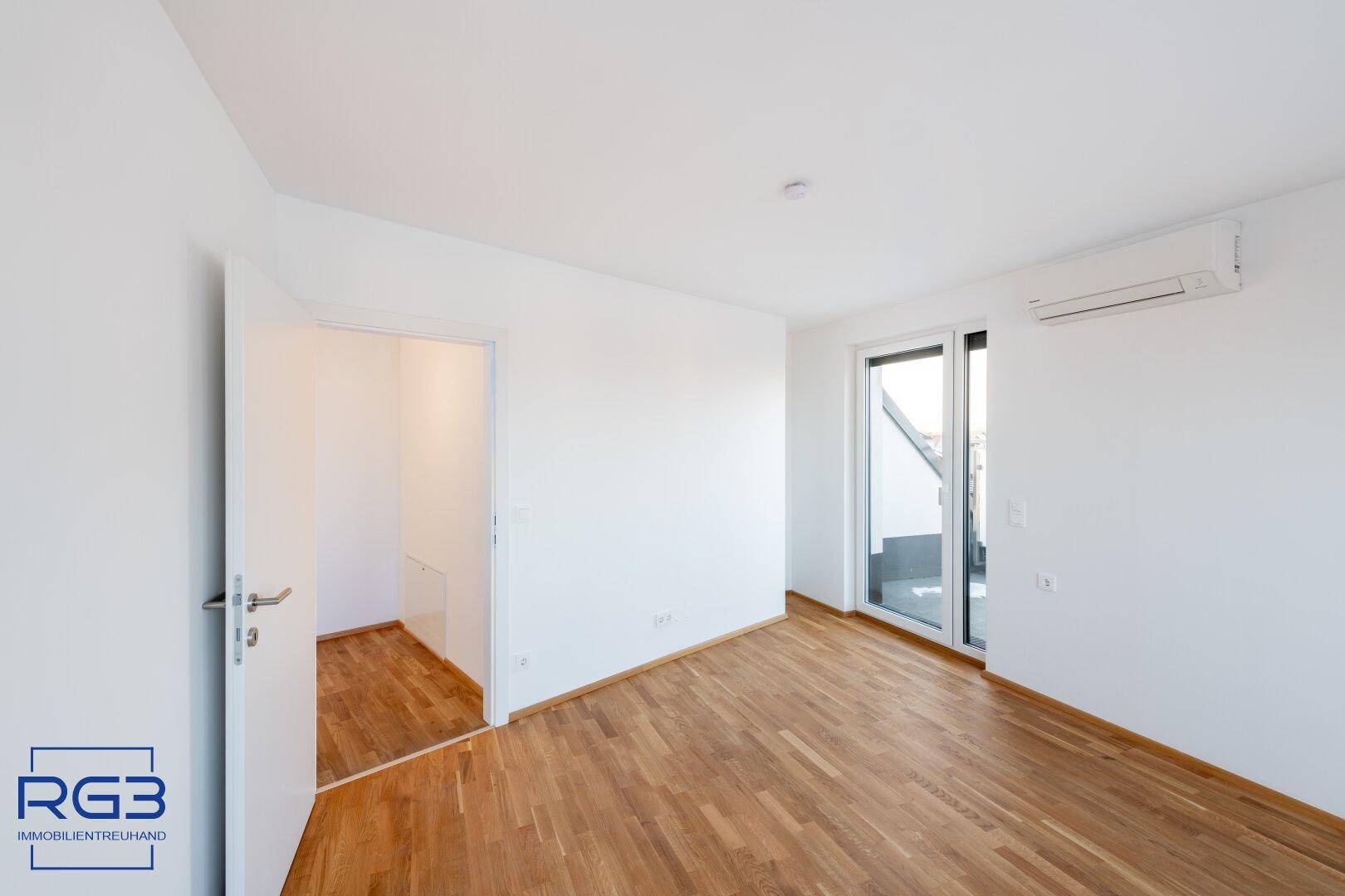 Heller Wohnraum mit Parkettboden und direktem Zugang zu einer sonnigen Terrasse.