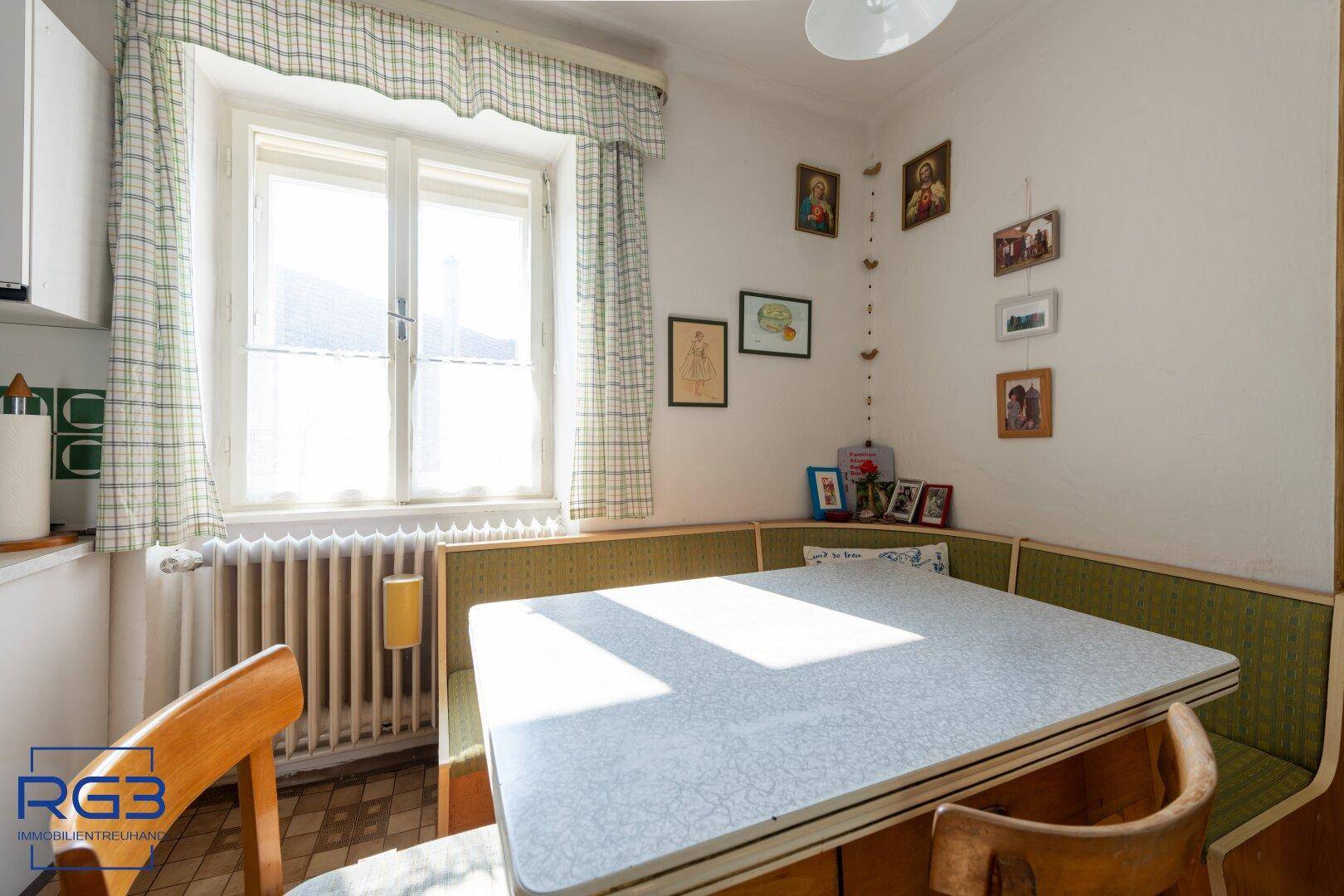 Gemütliche Wohnküche mit Eckbank, Esstisch und Fenster, das viel Tageslicht hereinlässt.