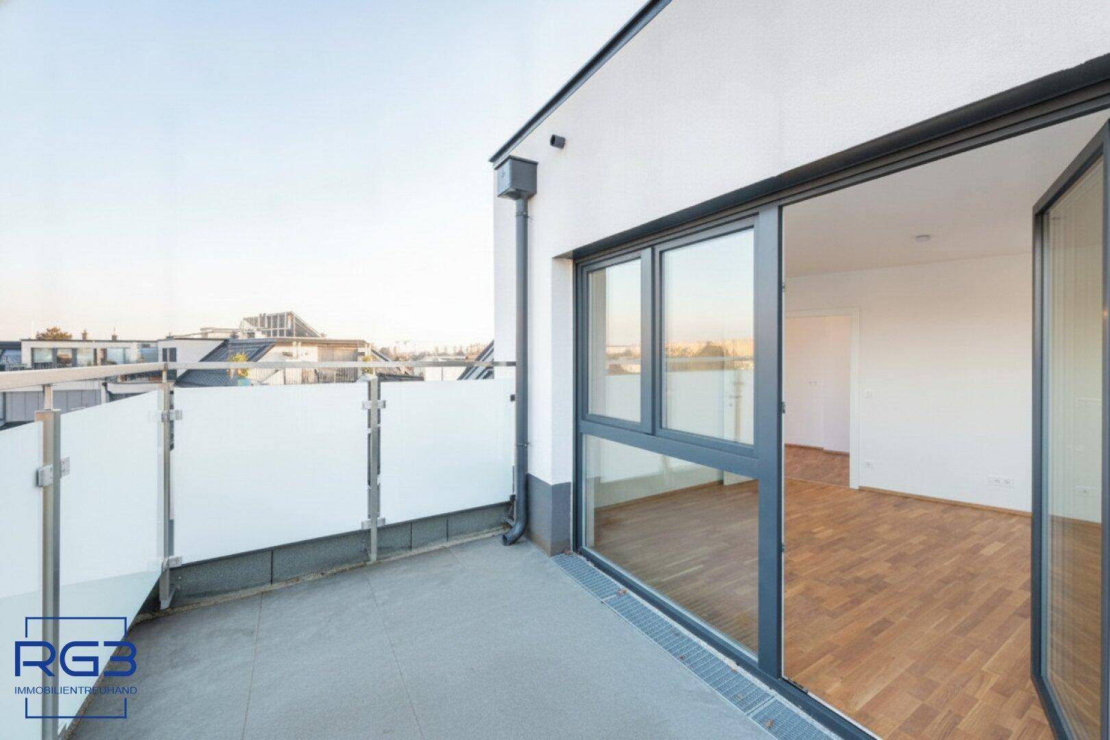 Geräumige Terrasse mit Schiebetüren und weitem Blick über die Dächer der Stadt.
