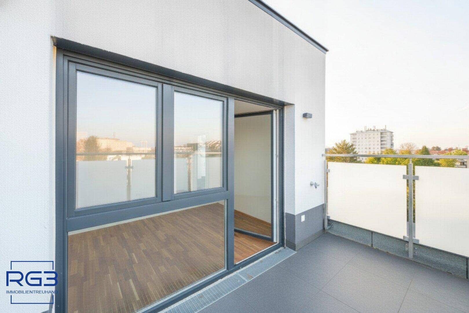 Moderne Terrasse mit Schiebetüren und Blick auf die Umgebung.