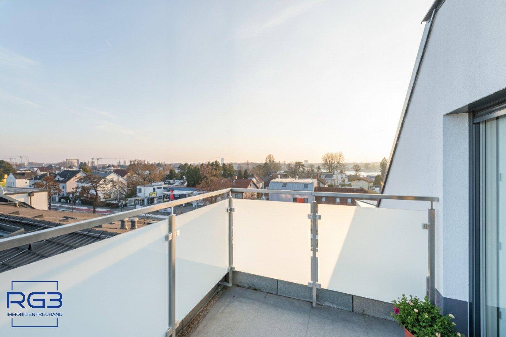 Moderne Terrasse mit Glasgeländer und weitem Blick über die städtische Umgebung.