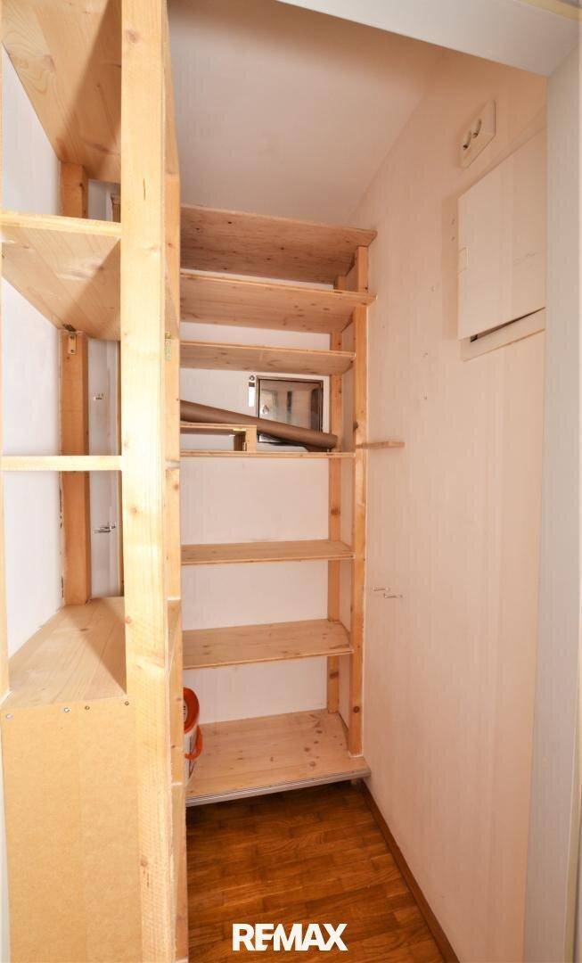 Praktischer Abstellraum mit stabilen Holzregalen für zusätzlichen Stauraum.