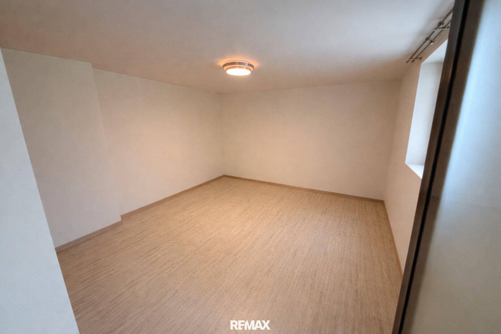 Helles, leeres Zimmer mit hellem Holzboden, ideal als Gästezimmer oder Büro nutzbar.