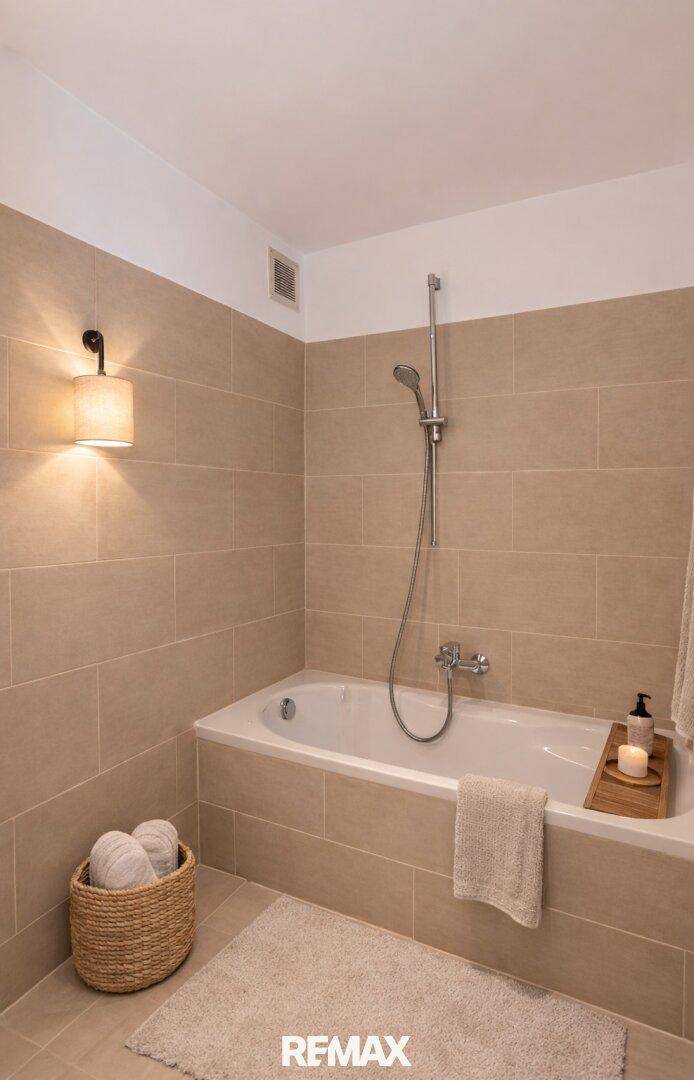 Modernes Badezimmer mit Badewanne, beigefarbenen Fliesen und Wandleuchte.