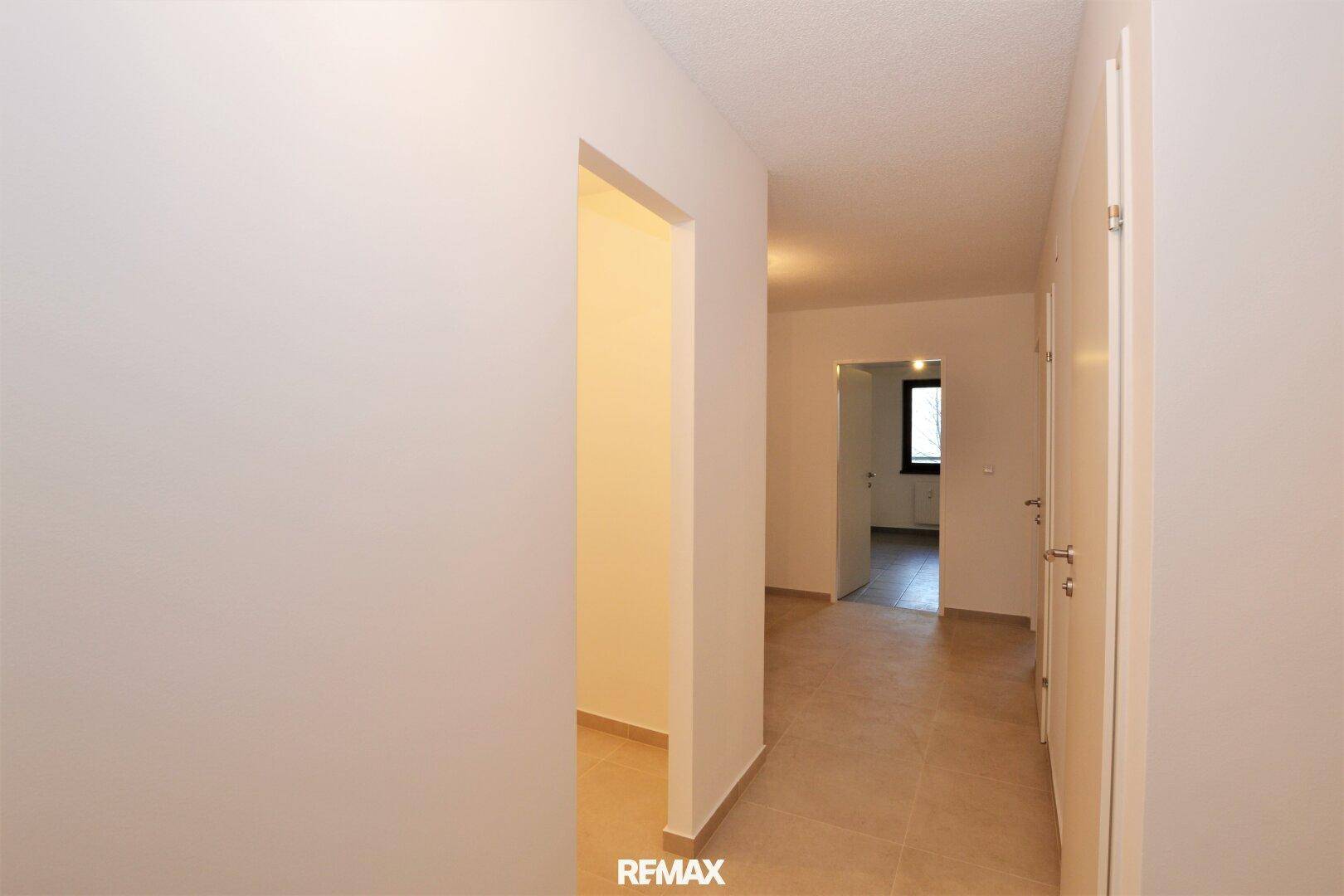 Heller Flur mit Fliesenboden und Türen zu angrenzenden Räumen.
