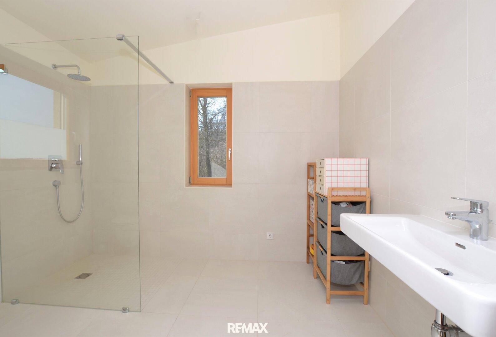 Modernes Badezimmer mit großer begehbarer Dusche, Einzelwaschbecken und Fenster.