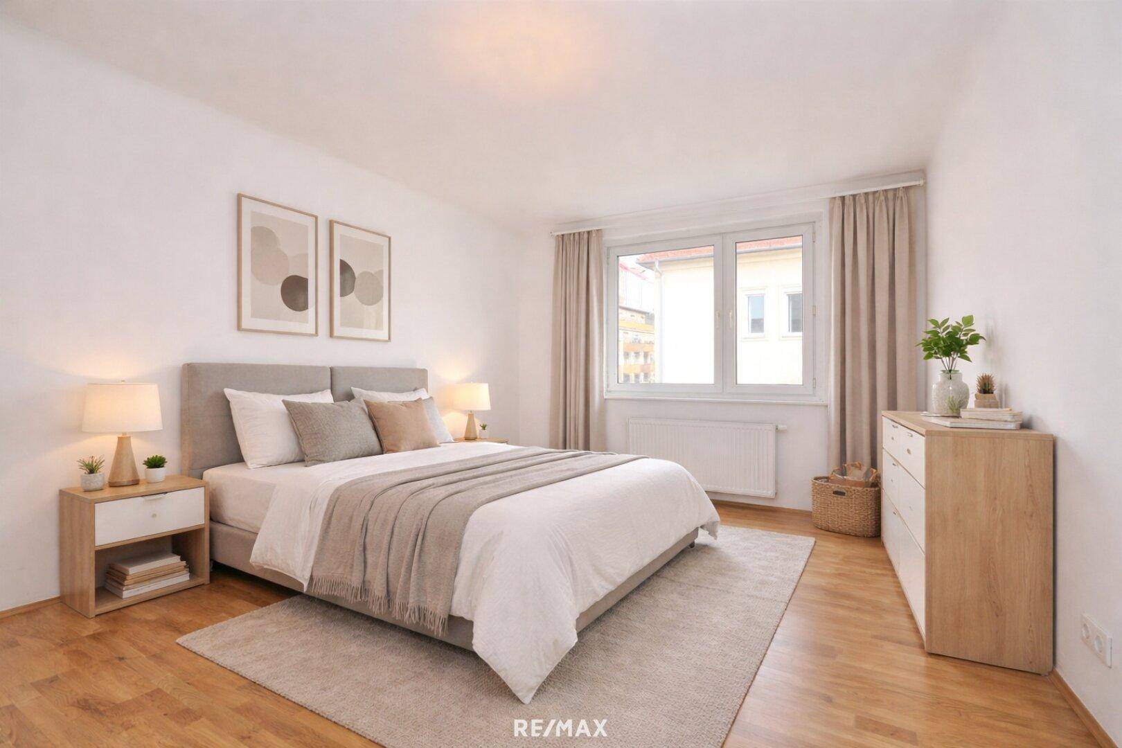 Helles Schlafzimmer mit Doppelbett, Holzboden und Blick ins Grüne.