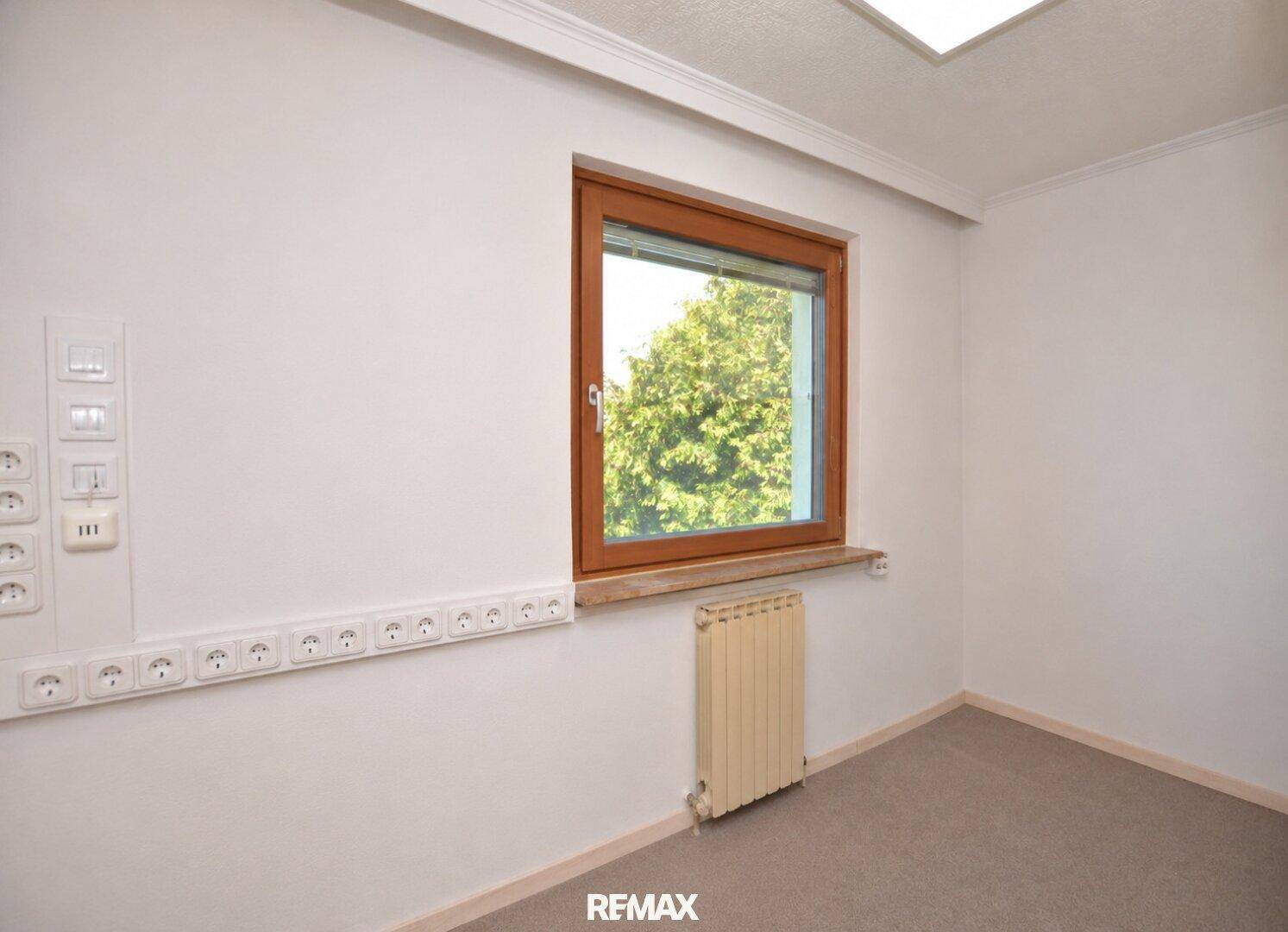 Kleiner Raum mit Fenster, Heizkörper und zahlreichen Steckdosen, ideal als Büro oder Hobbyraum.