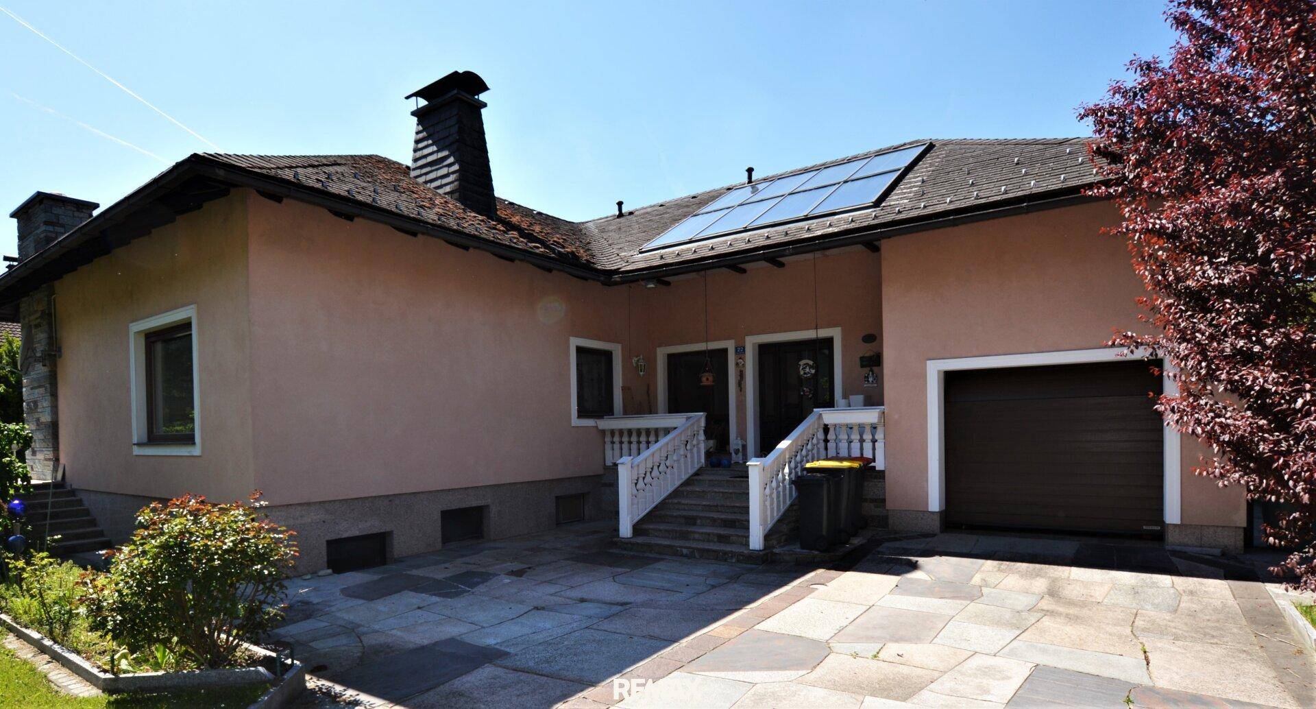 Ansicht des Einfamilienhauses mit Garage, Eingangsbereich und Solaranlage auf dem Dach.