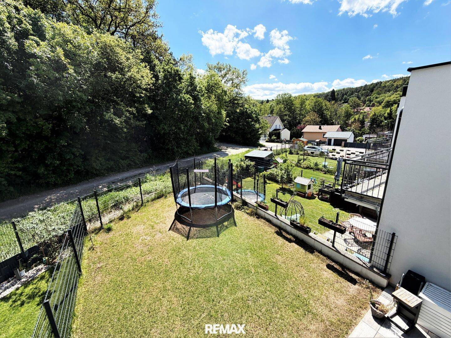 Weitläufiger Garten mit Trampolin und Blick auf die grüne Hügellandschaft.