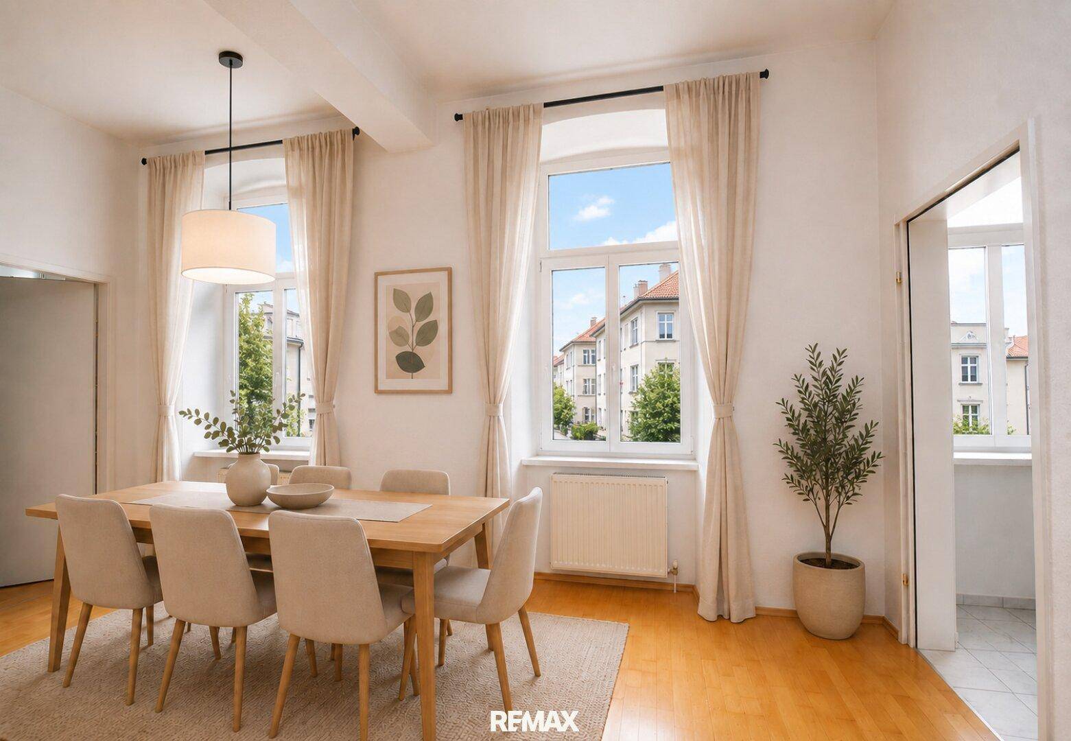 Heller Essbereich mit Holztisch, bequemen Stühlen und Blick auf die Stadt durch große Fenster.