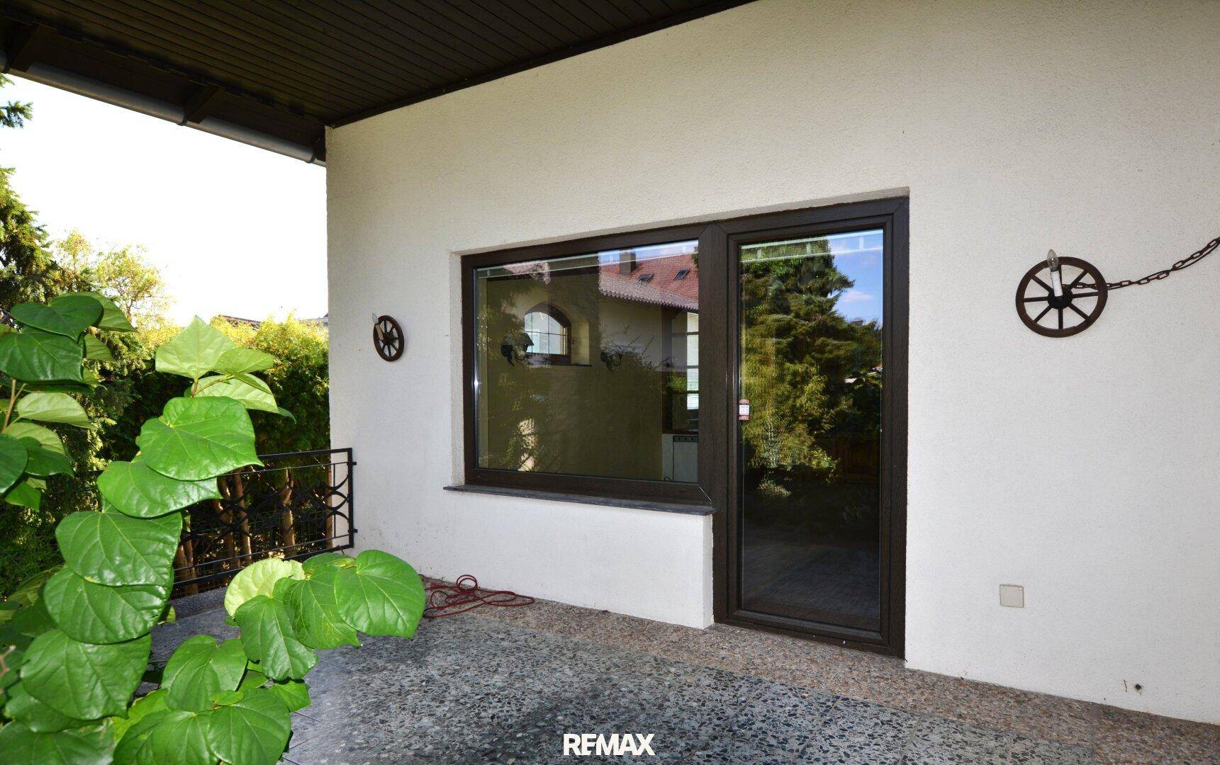 Überdachte Terrasse mit Zugang zum Garten, ideal für entspannte Stunden im Freien.