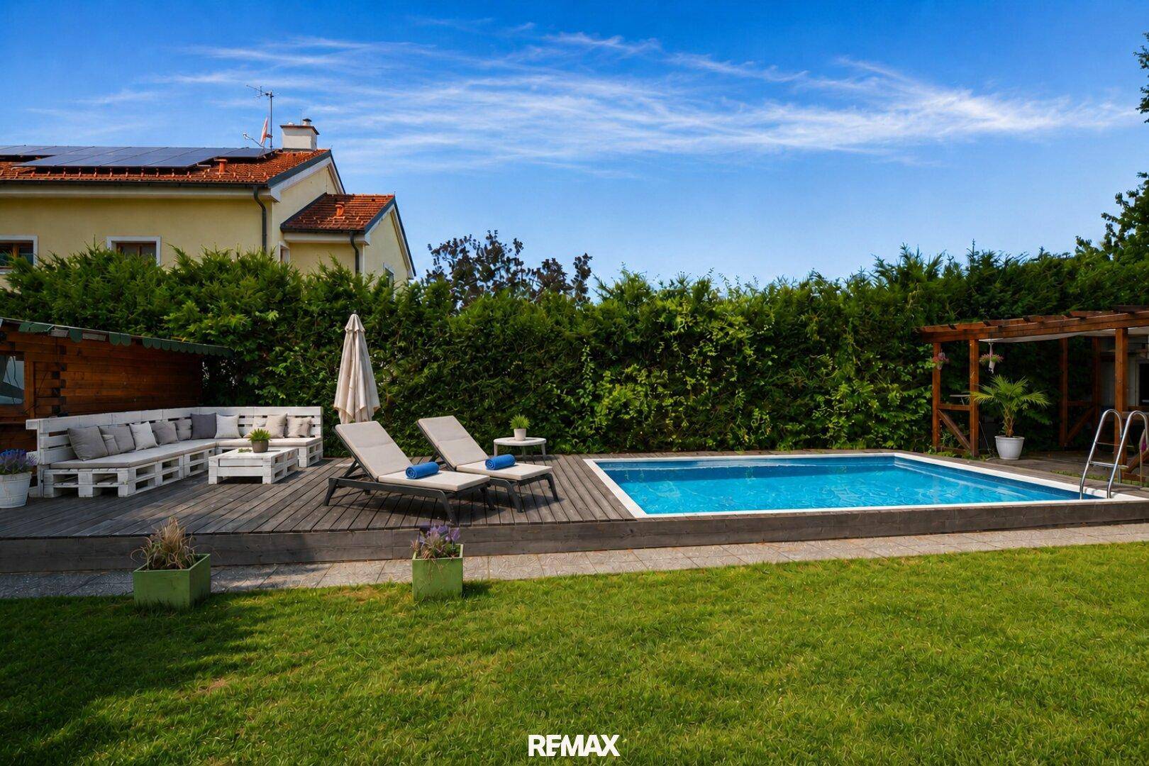 Gepflegter Garten mit Pool, Holzdeck, Liegestühlen und einer gemütlichen Lounge-Ecke.